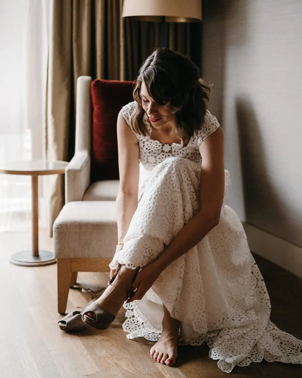 Die Braut Lena zieht sich ihre Schuhe an im Hotel um kurz danach zur Zeremonie für ihr Vow Renewal am Tegernsee zu starten.