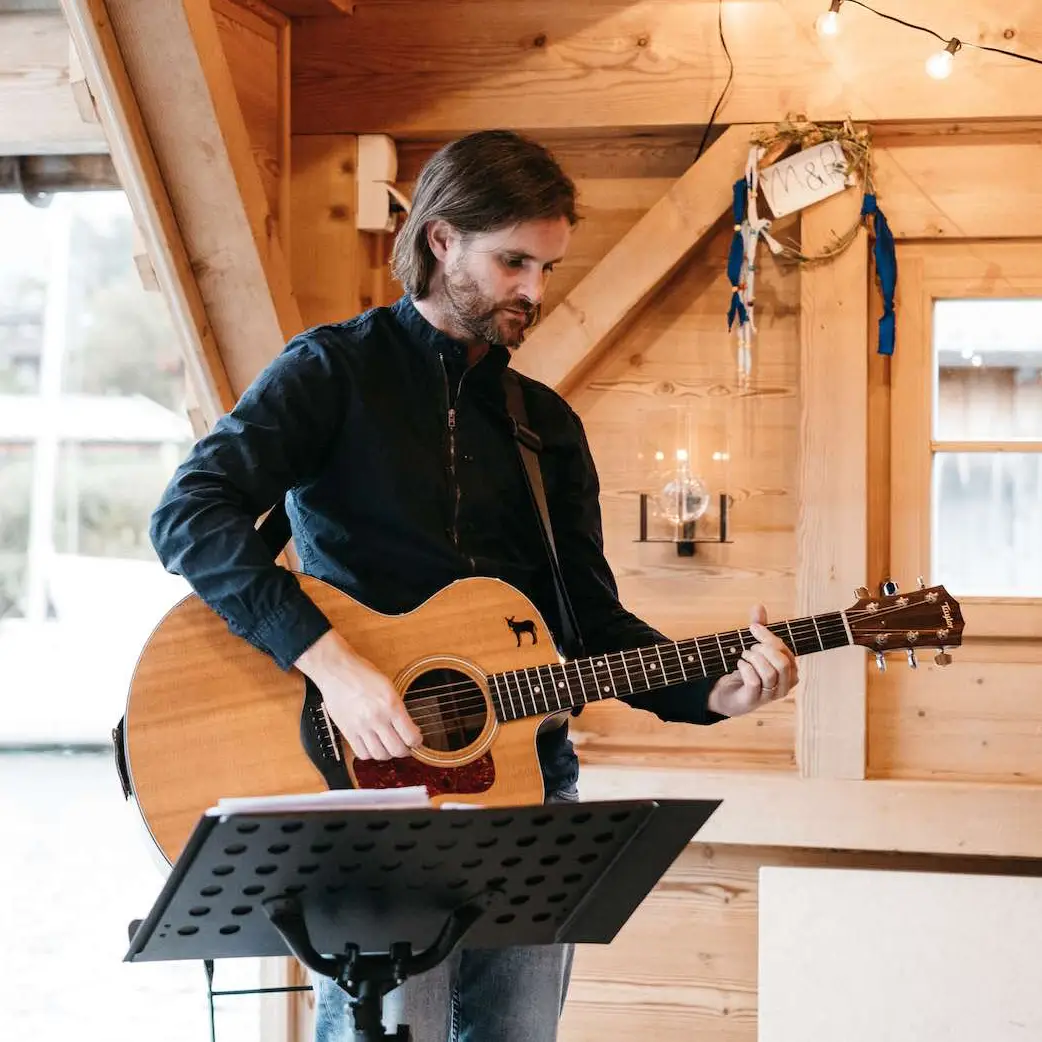 Ein Sänger mit Gitarre im Bootshaus für die kleine Hochzeit zu zweit.
